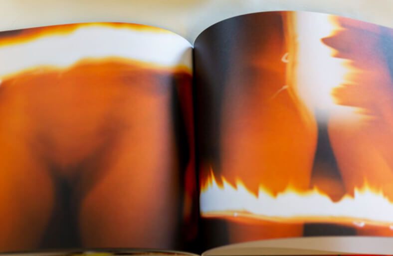Photo book spread showing abstract orange and red light formations.