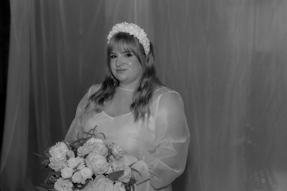 A black and white bridal portrait featuring a woman holding a bouquet of flowers.