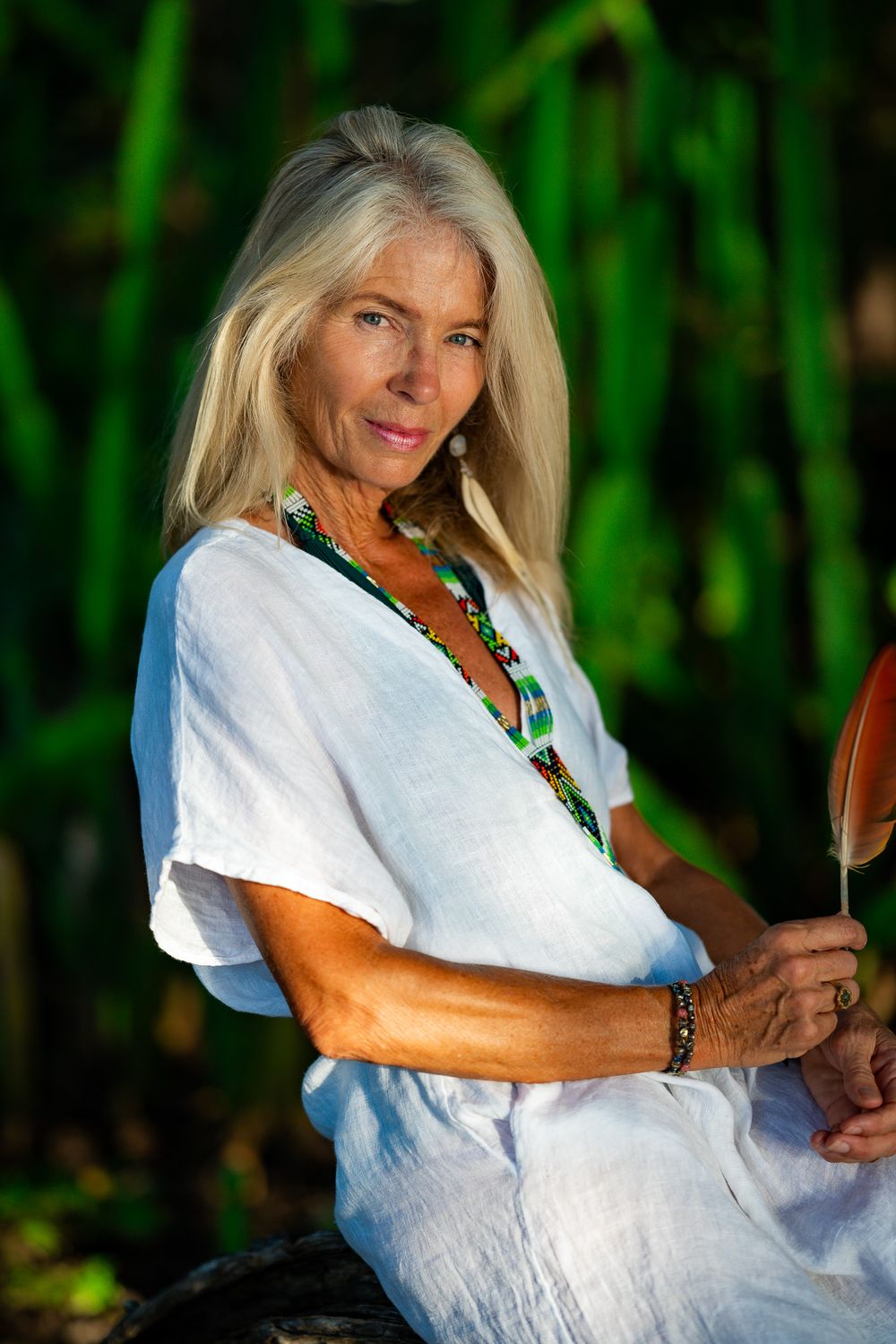 Elderly women holding a feather during a lifestyle portrait photoshoot in Playa Negra Costa Rica