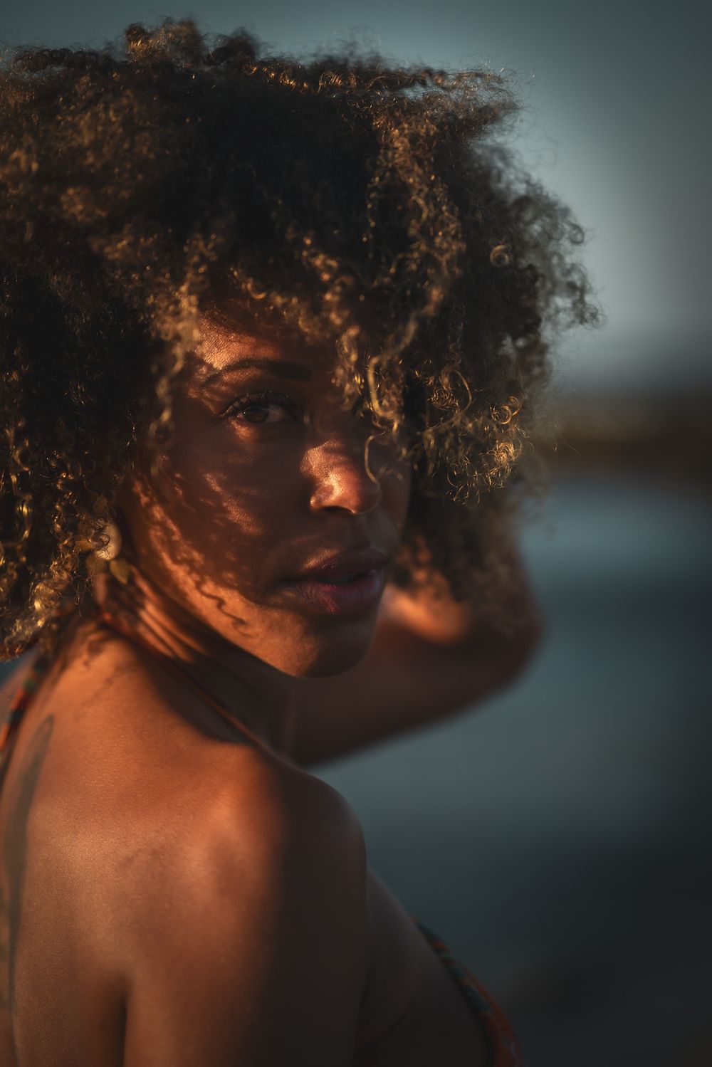 Coloured women behind a leaf during a lifestyle portrait photoshoot in Playa Negra Costa Rica