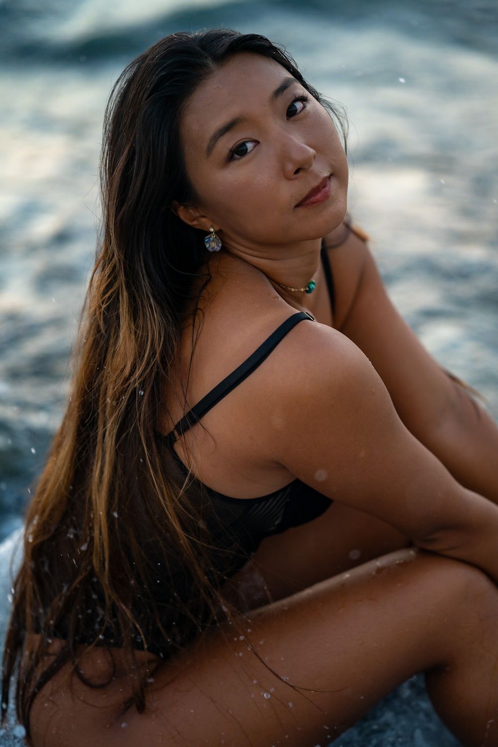 Asian women boudoir photo sat in the water during a lifestyle portrait photoshoot in Playa Negra Costa Rica