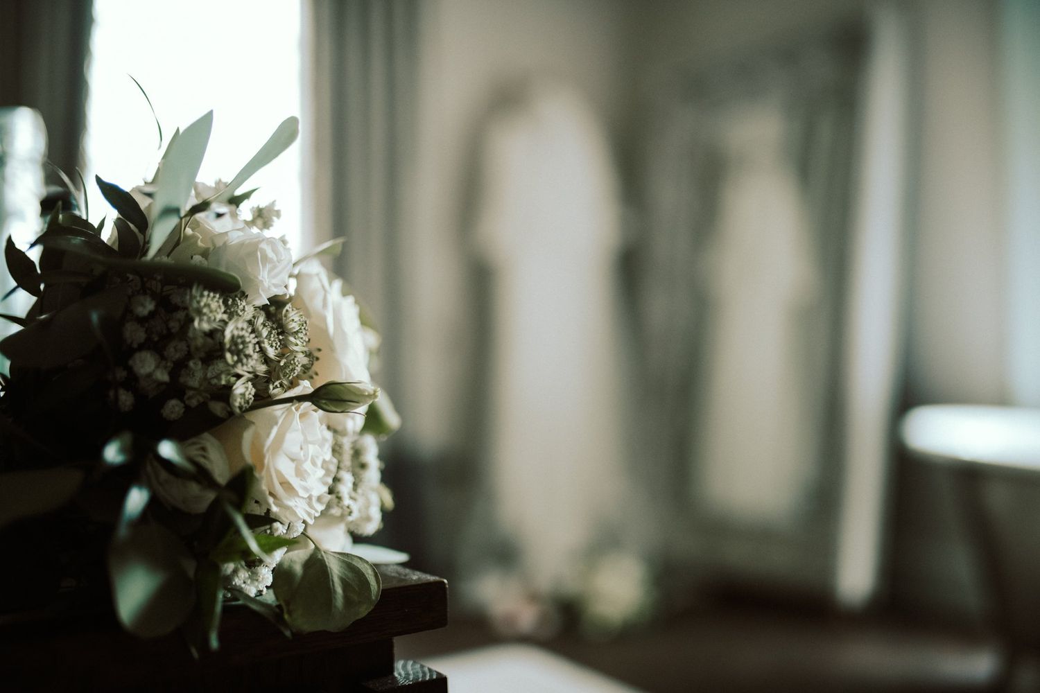 White floral arrangements and decor create an elegant wedding atmosphere in soft focus. Saltmarshe Hall