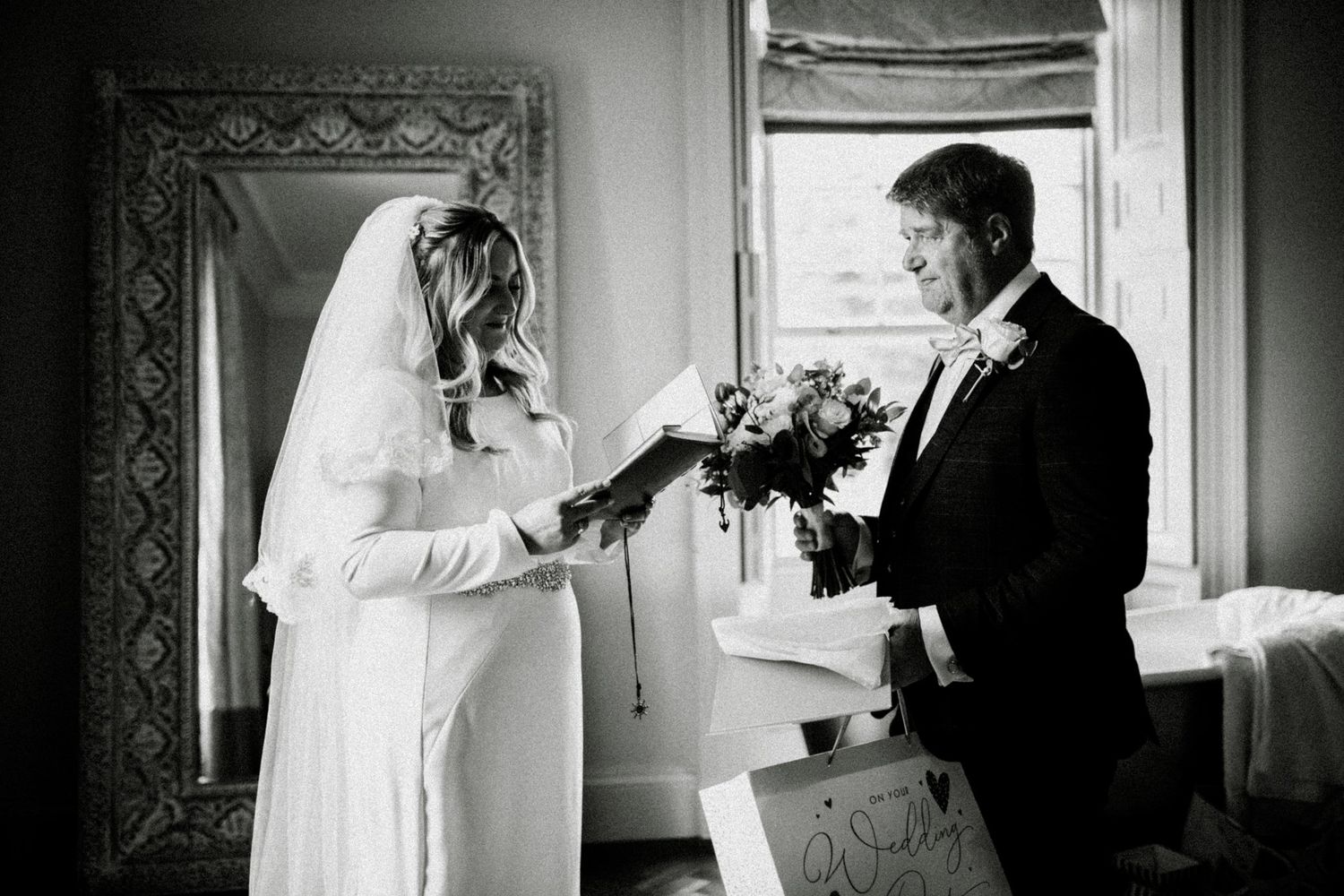 Classic black and white wedding photography captures intimate moments in a vintage interior setting.