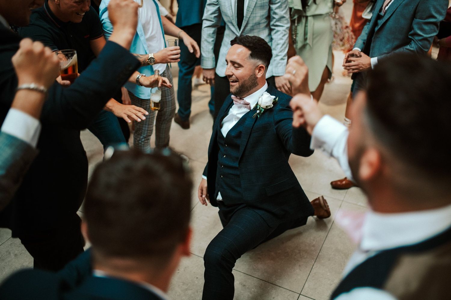 Energetic crowd of wedding guests enjoying themselves at the reception party.