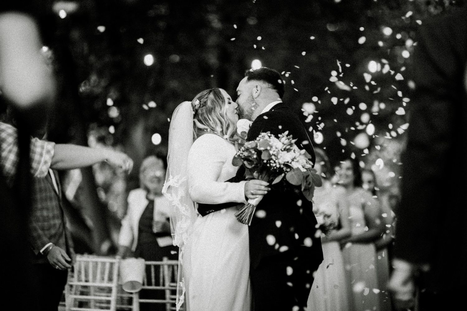 Black and white photo of a romantic first dance moment with confetti falling. Saltmarshe Hall