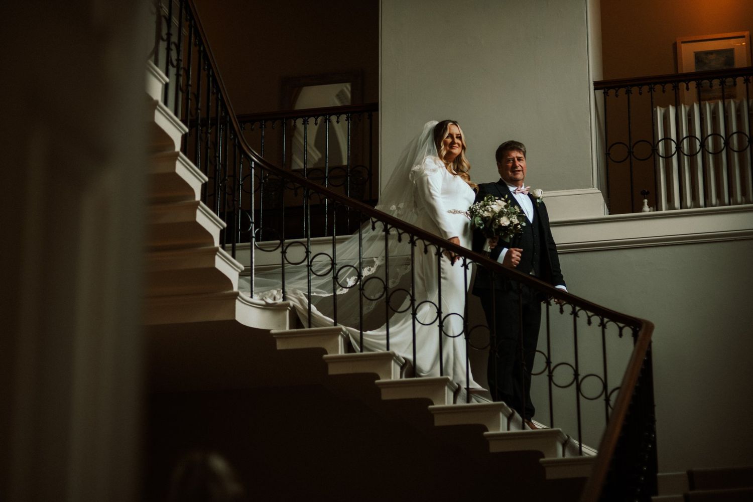 Elegant staircase with wrought iron railings in a wedding venue interior. Saltmarshe Hall