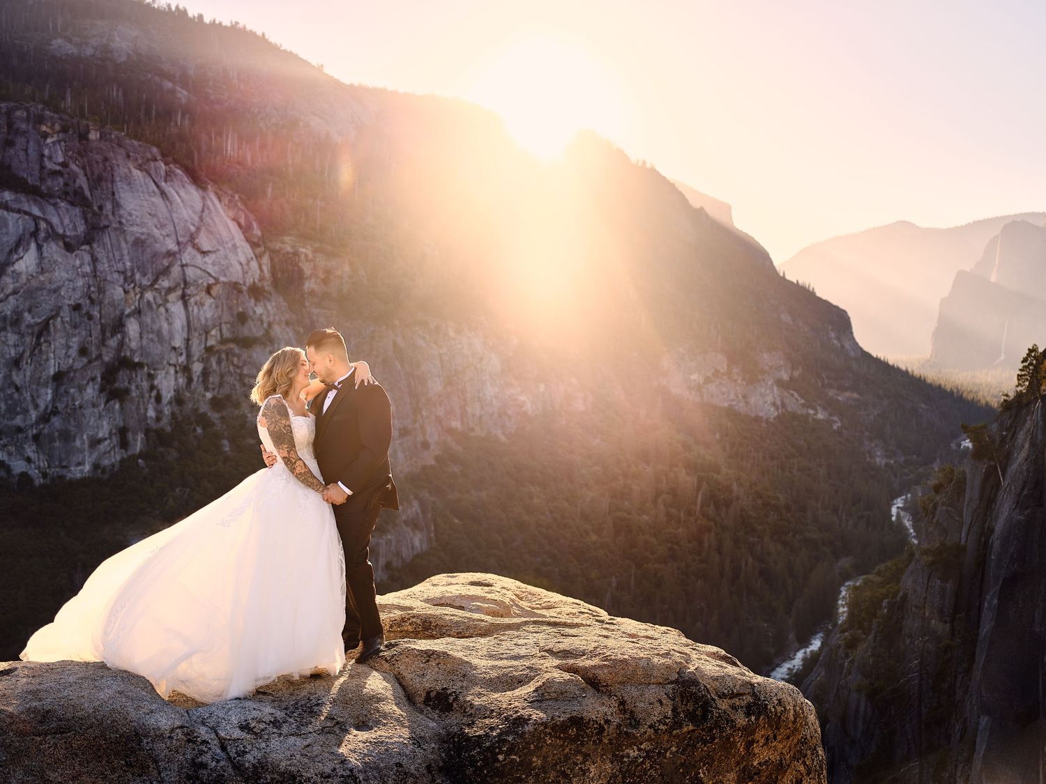 Bride and groom with sunrise over Yosemite Valley from secret spot