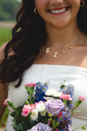 a girl feeling the sun with a bouquet of pink and purple flowers