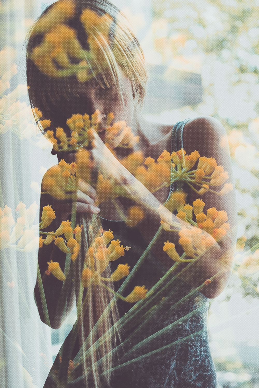 Double exposure portrait overlaid with yellow flowers creating dreamy effect.