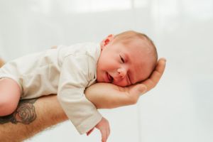 Melissa Stuer Photography Moederschapsfotograaf Moerbeke Oost-Vlaanderen newborn baby liggend op arm papa newbornfotograaf