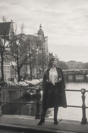 Black and white photograph of a canal in Amsterdam with historic buildings along the waterfront.