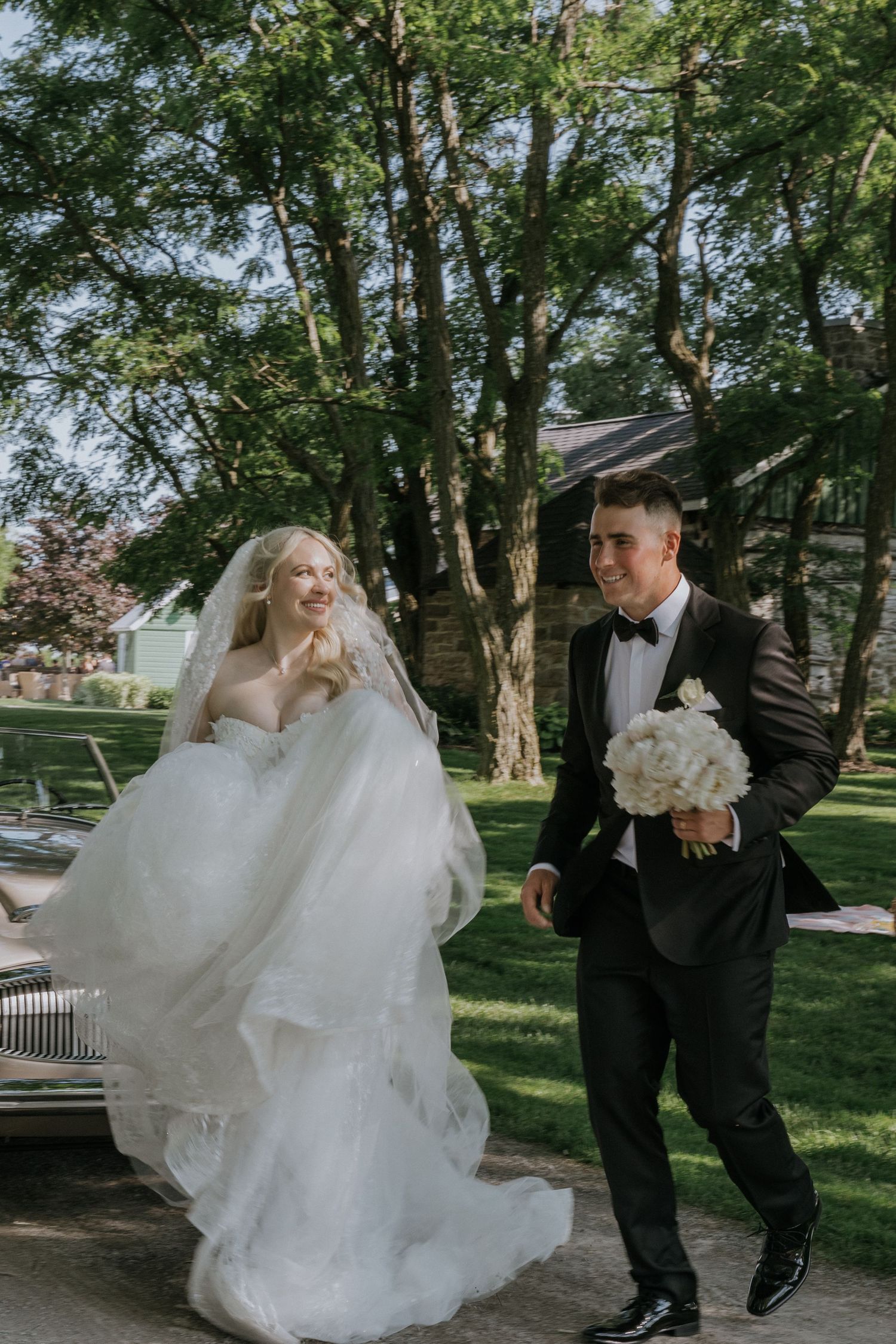 Romantic wedding dance sequence showing couple in white dress and dark suit on garden path.