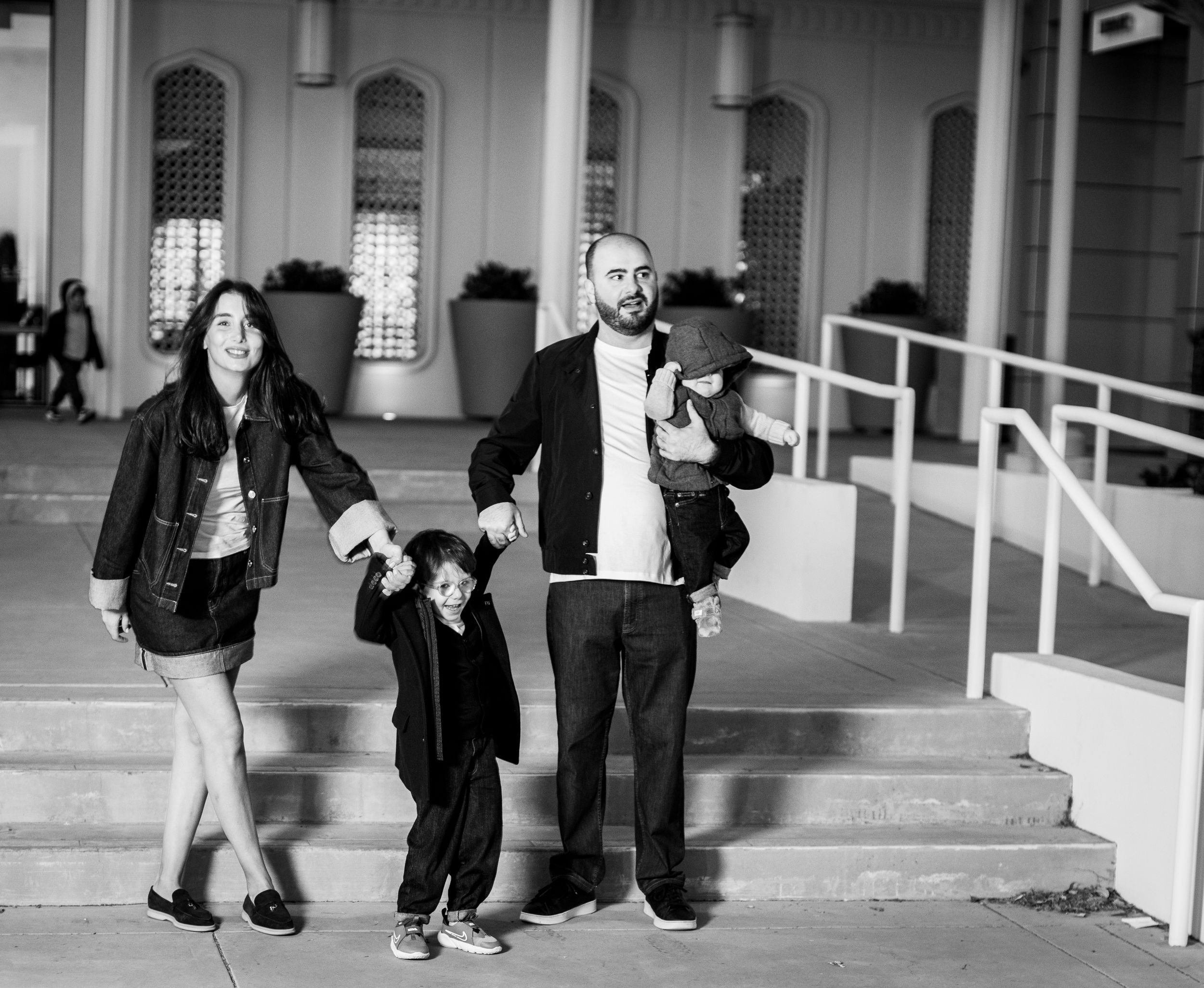 Black and white photo of family walking together on outdoor steps.
