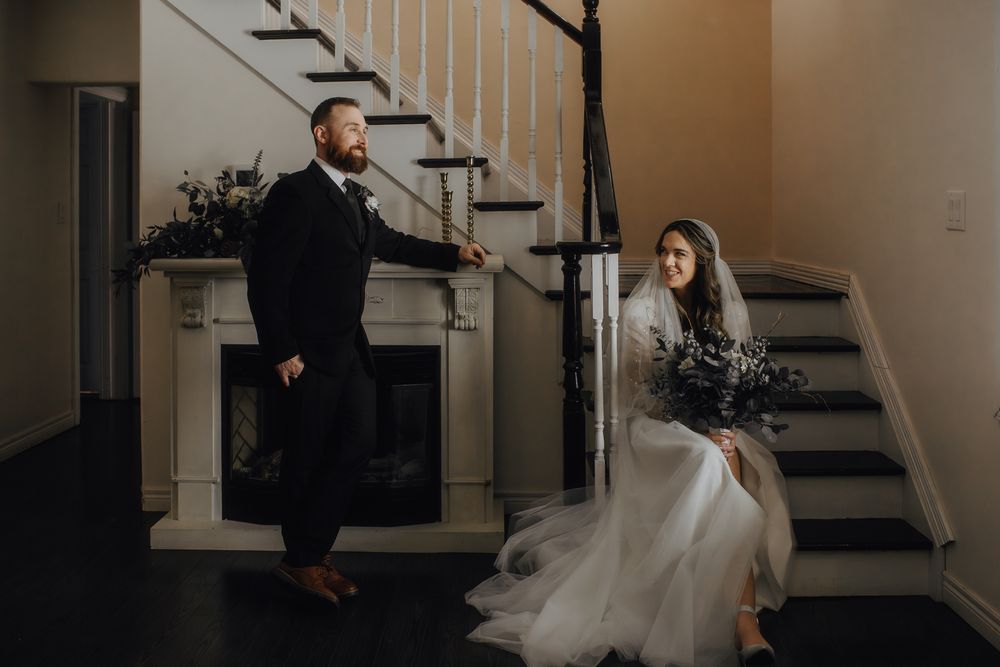 Dramatic staircase scene with couple in wedding attire.