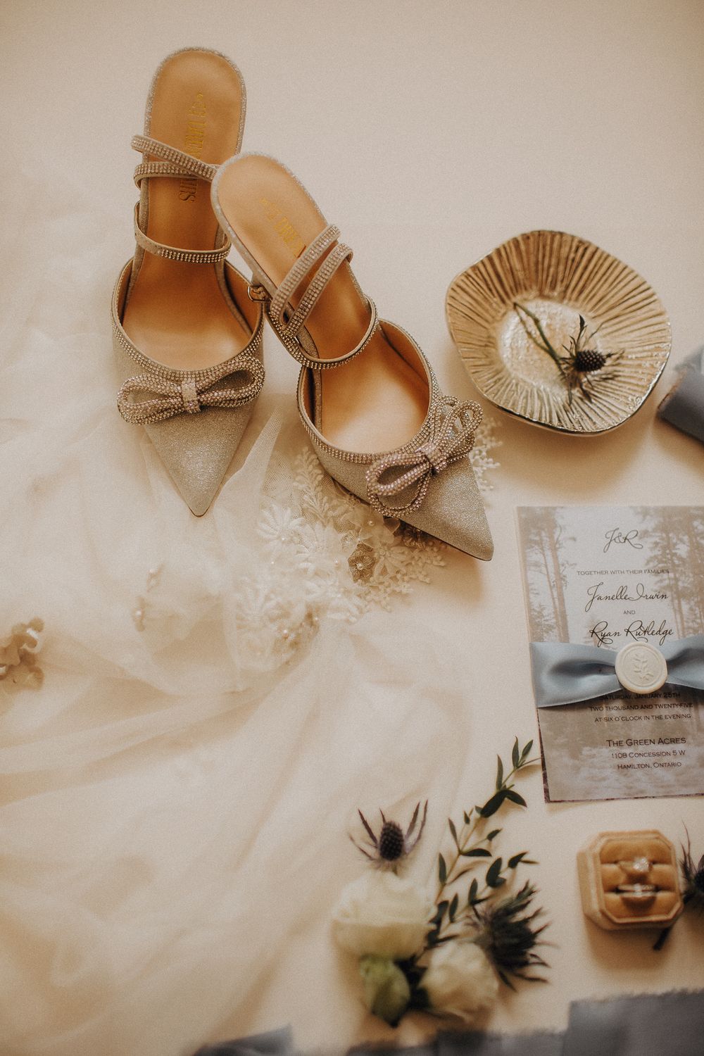 Wedding details including nude heels, invitation cards and delicate accessories.