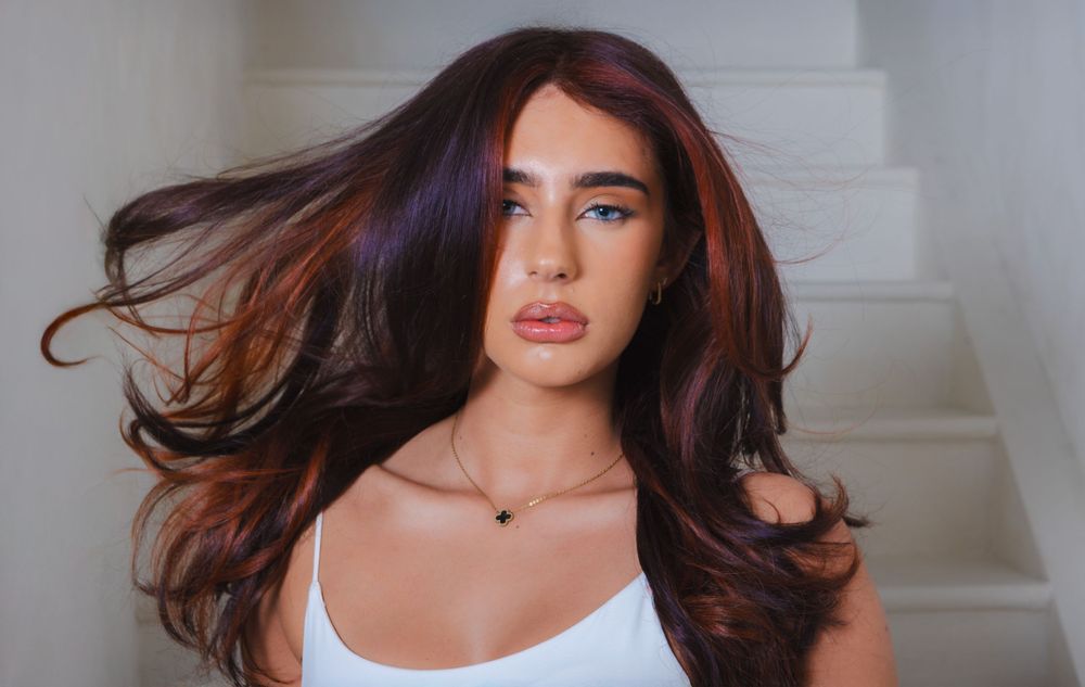 Fashion model poses in different angles wearing a white tank top with dynamic hair movement.