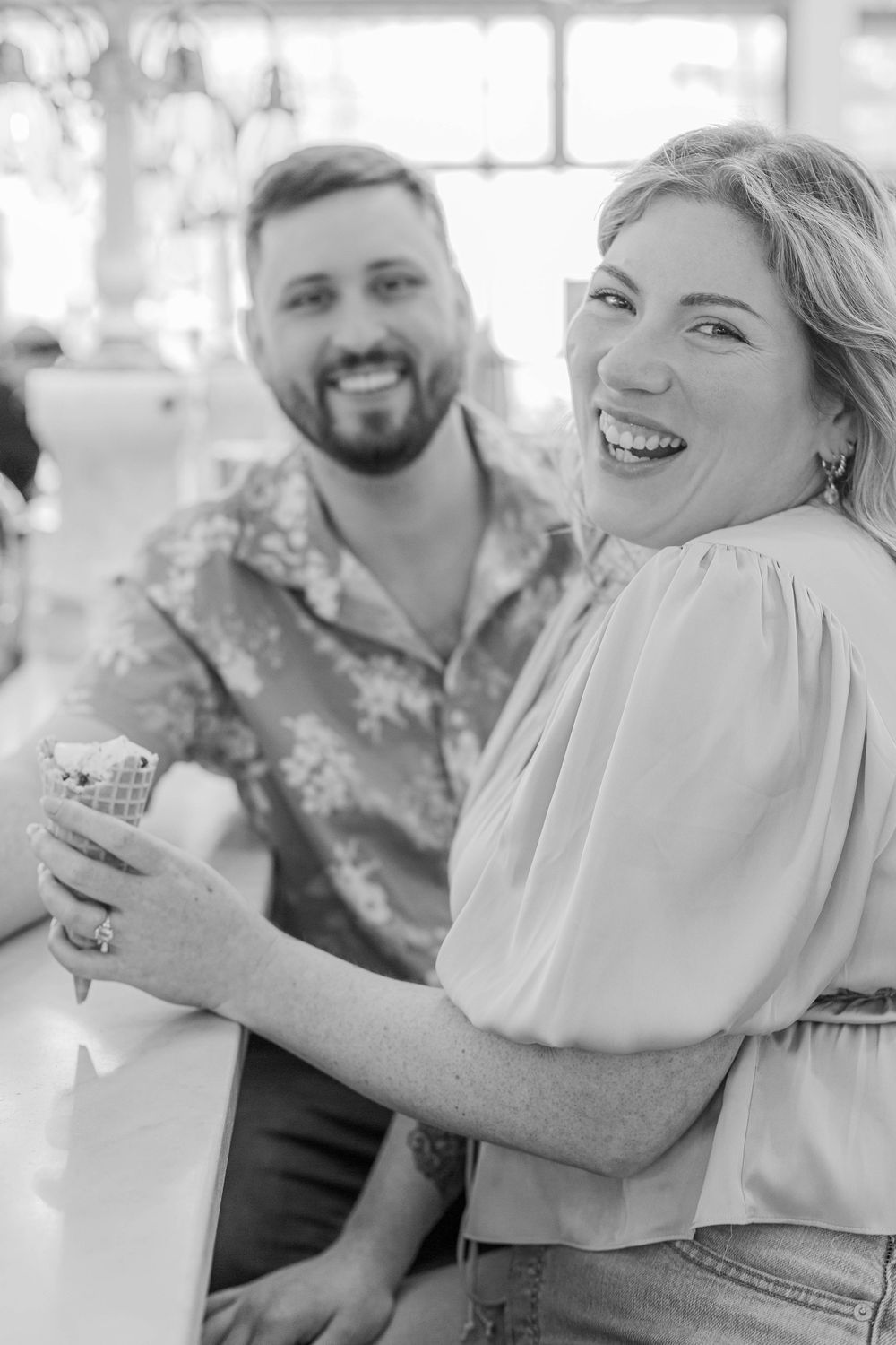 Happy couple sharing a candid moment together outdoors in black and white photography.