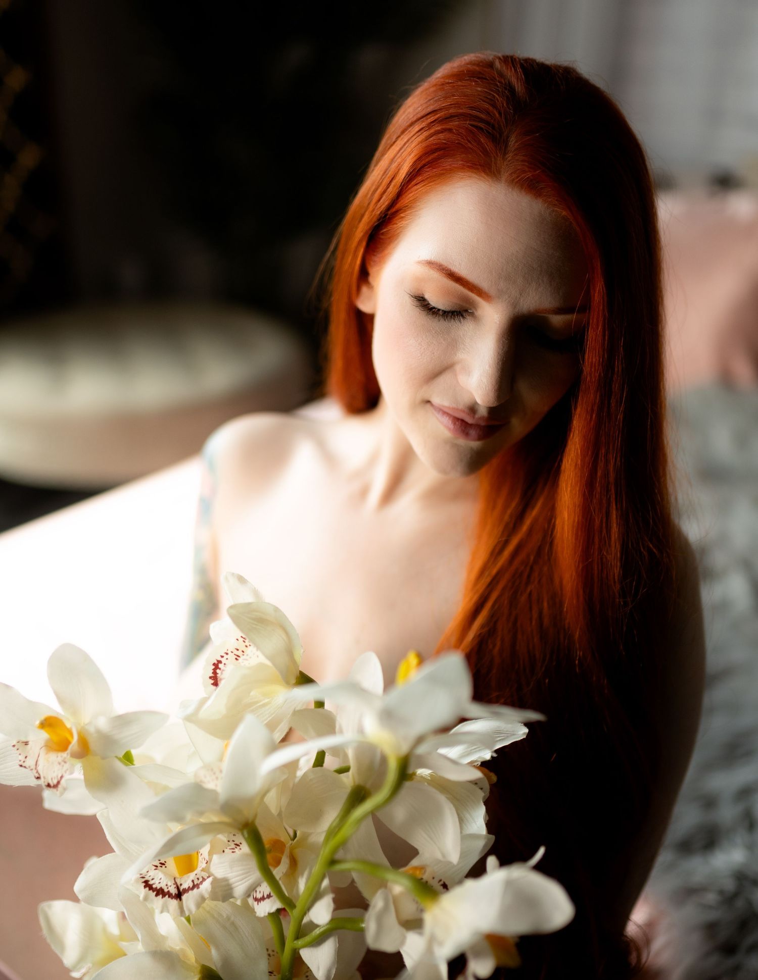 Soft portrait with white orchids in natural window light.