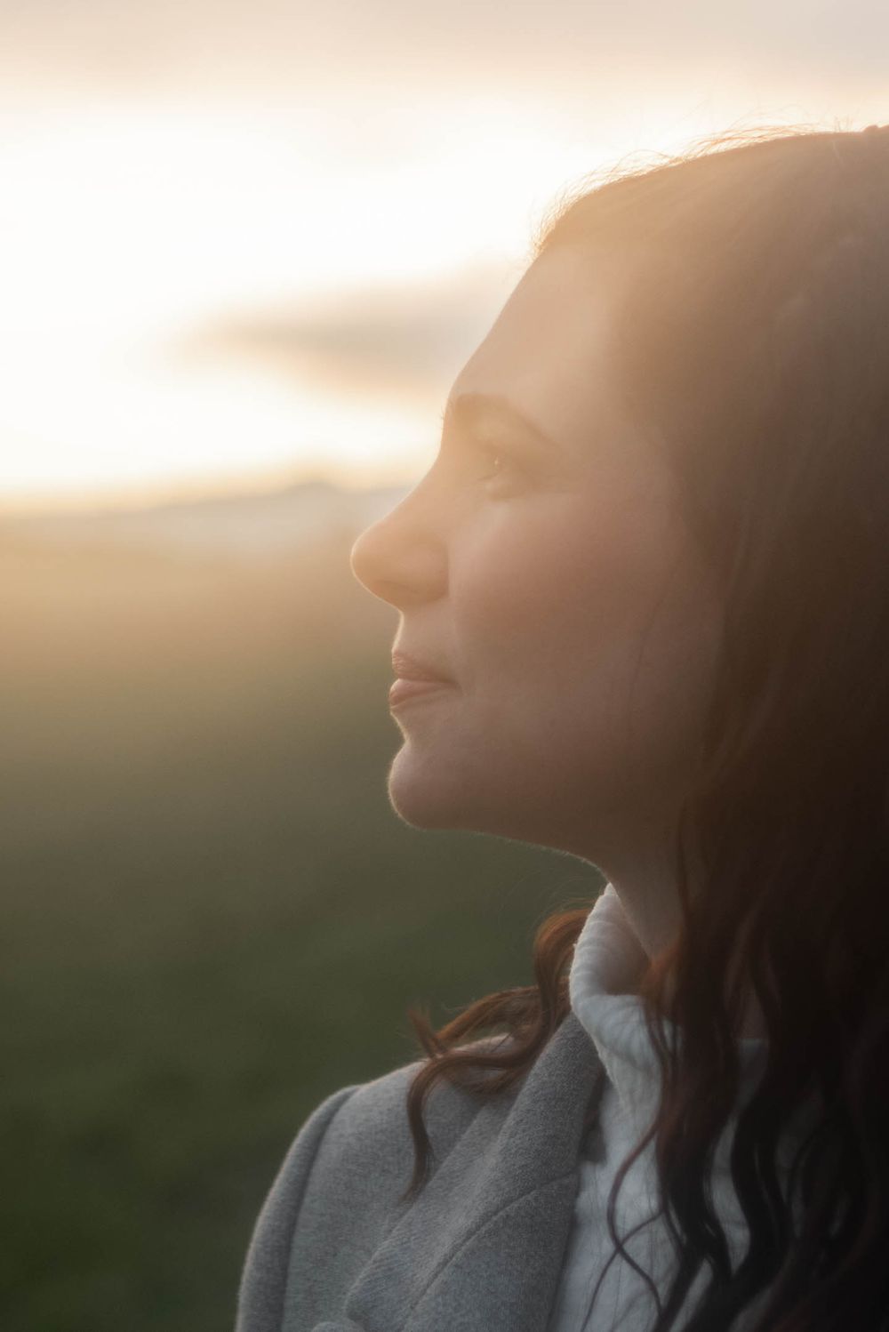 Silhouette portrait in golden hour light against natural landscape.