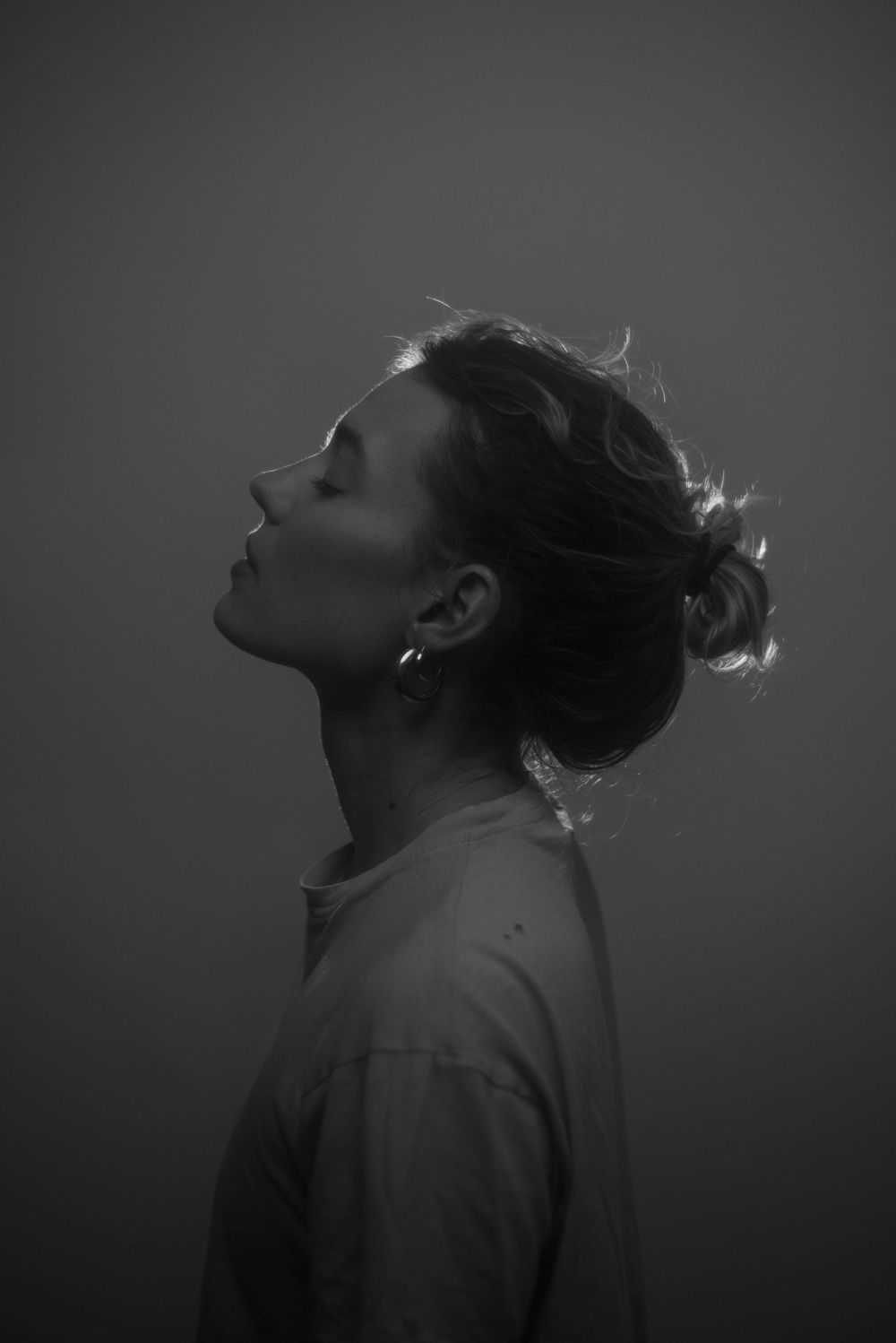 Dramatic black and white profile portraits showing emotional expressions in dark lighting.