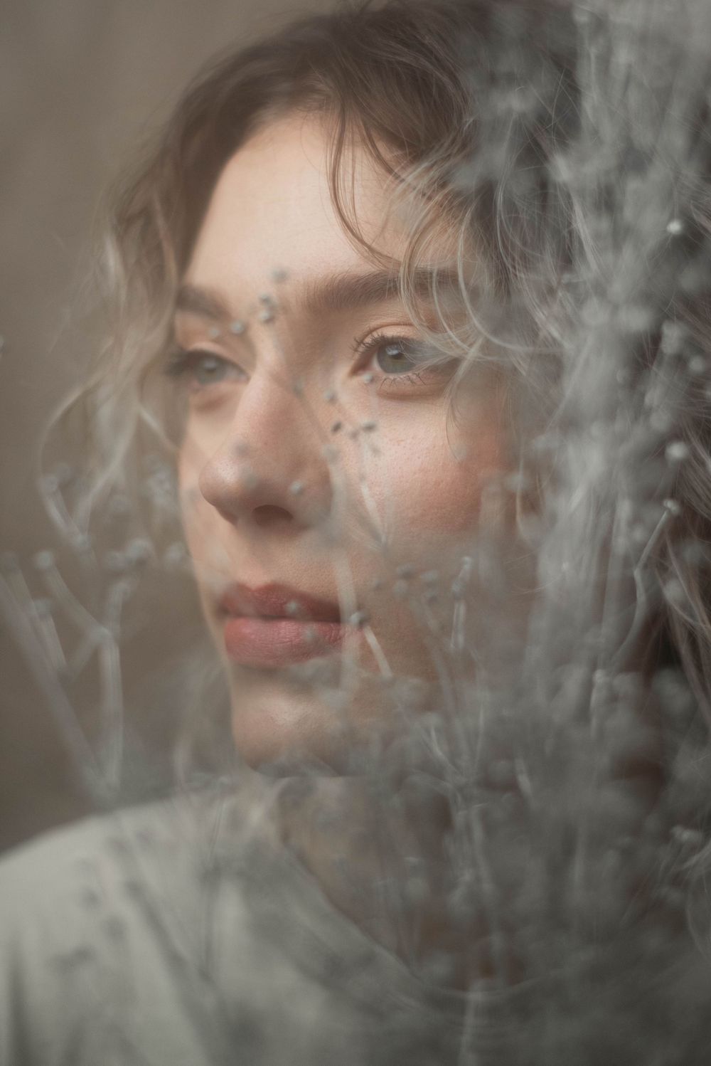 Ethereal portrait through smoke or fog creating a dreamy, soft-focus effect.