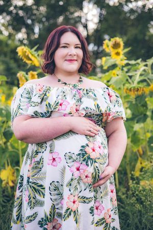 Floral dress against yellow sunflowers in outdoor garden photoshoot series.