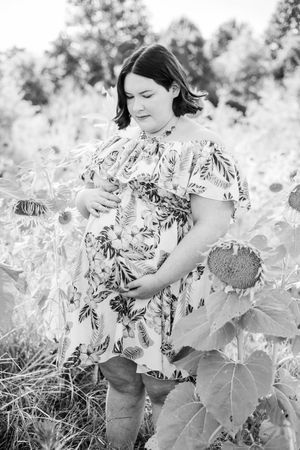 Black and white series of photos showing someone exploring a sunflower garden in summer.