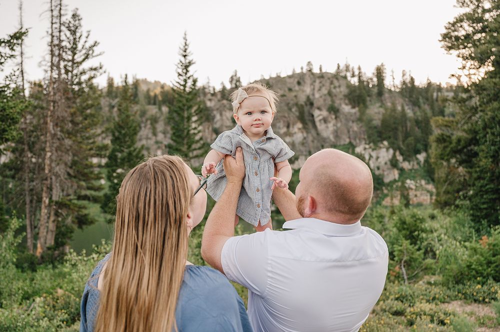 Joyful moment captured against scenic mountain backdrop with evergreen trees.