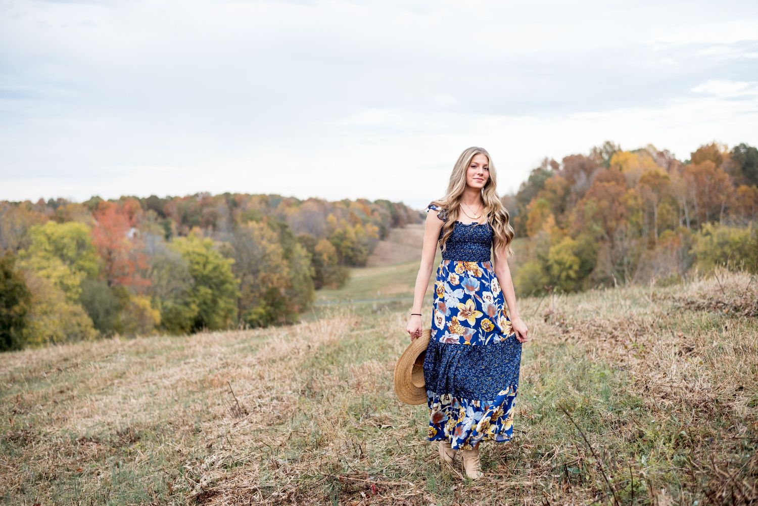 Senior portrait of a girl in a long dress walking in a field in Kentucky