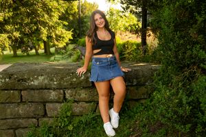 A series of five similar outdoor photos showing someone sitting on a stone wall surrounded by lush greenery in sunlight.