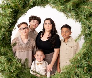 Holiday portrait session with evergreen branches and festive Christmas decor.