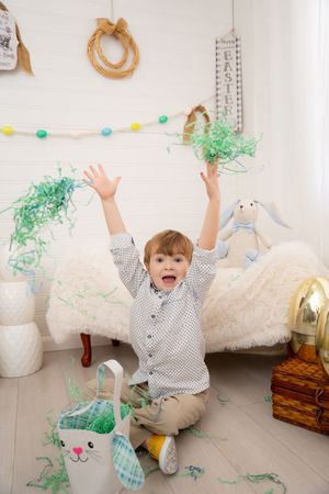A sequence of playful moments showing someone throwing green tissue paper confetti in a white room with decorative accents.