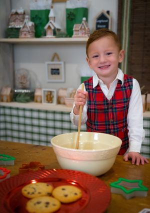 A child in a plaid vest stirs ingredients in a mixing bowl during a holiday baking session.