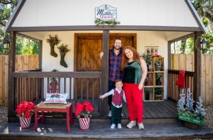 Exterior of rustic event venue decorated with holiday wreaths and Christmas decor.