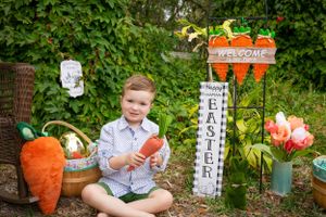 A spring garden display featuring decorative carrots and welcome signs.
