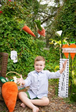 A garden setting with decorative white fences and large orange carrot props.