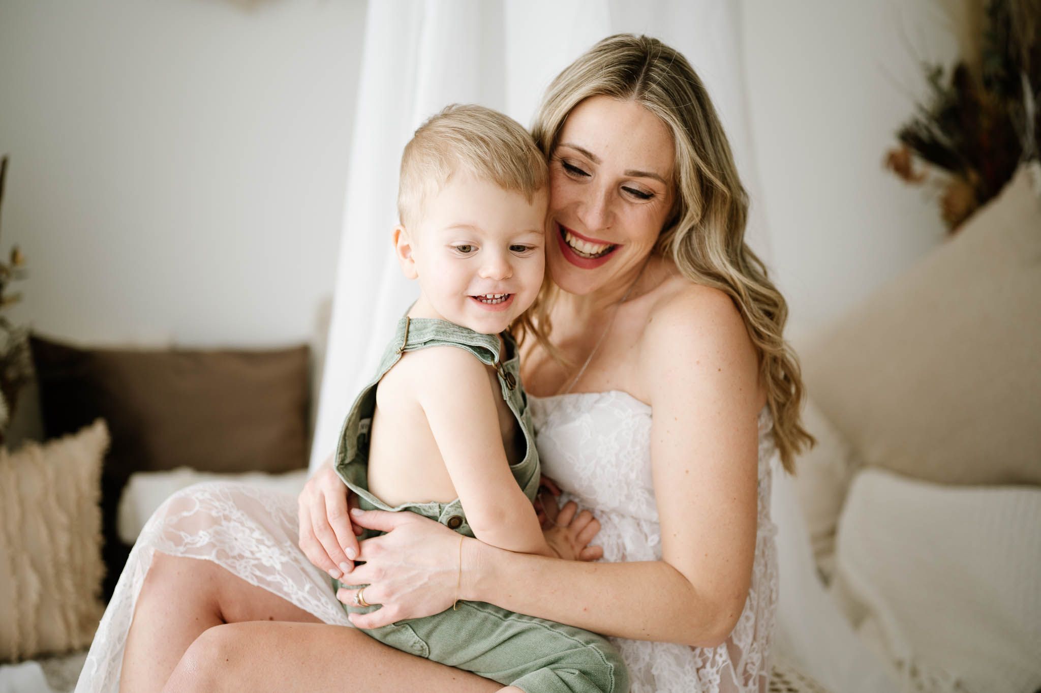 Tender embrace between mother and child with natural light streaming through window.