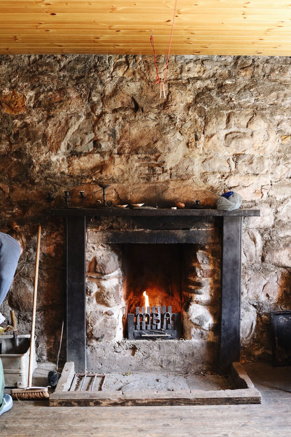 Ancient stone cellar with multiple fireplaces built into rustic walls showing historic cooking and heating methods.