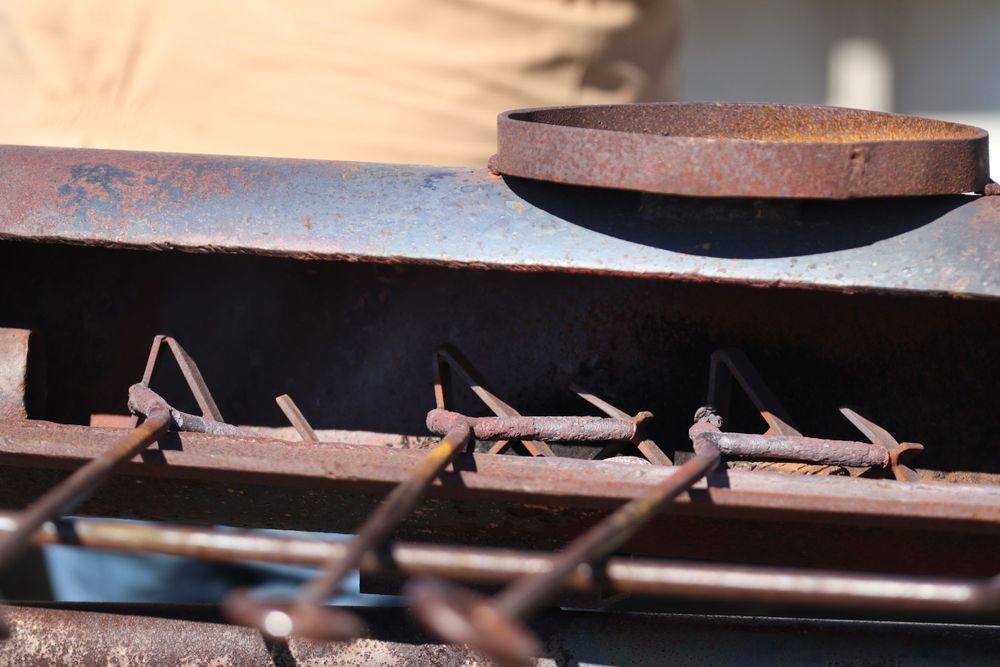Close-up of rustic metal grating or machinery parts in dark shadows.