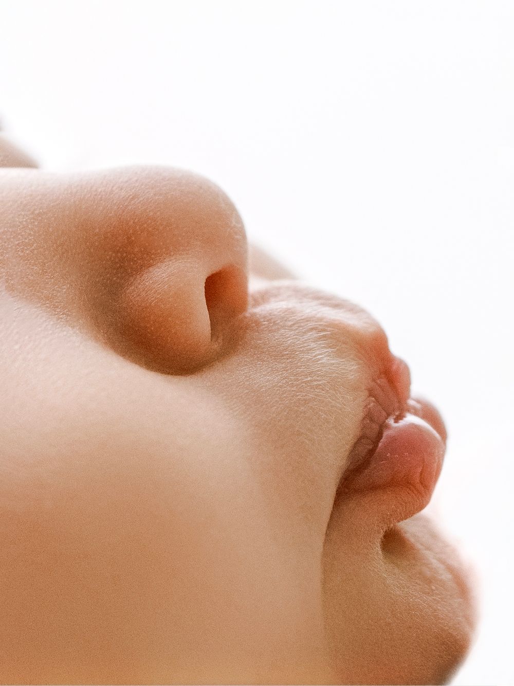 Close-up profile view of a baby's nose against a soft white background.