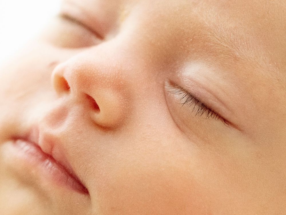 Close-up view of delicate baby skin showing gentle features in soft natural lighting.
