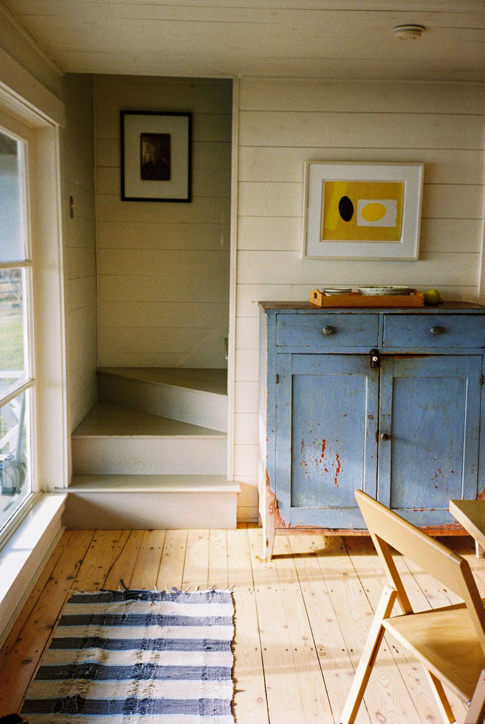 Detail of the kitchen and stairwell with an artist portrait of Georgia O'Keefe in the back ground.