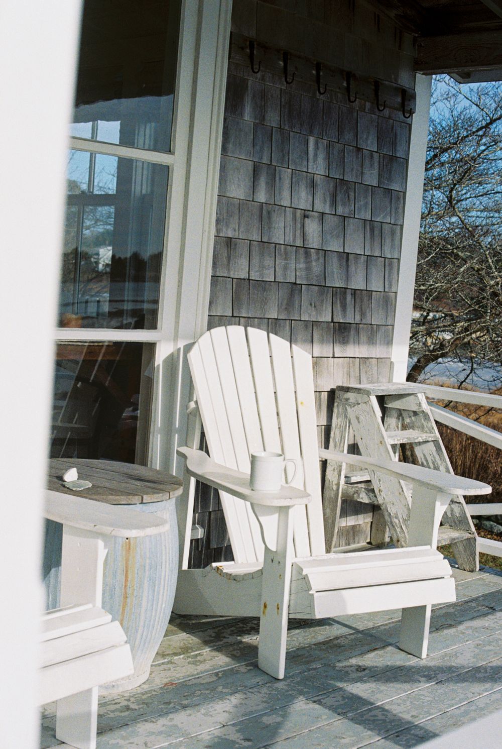 Coffee and Adirondack chairs on the porch at Harbor Cottage in Martinsville, Maine.