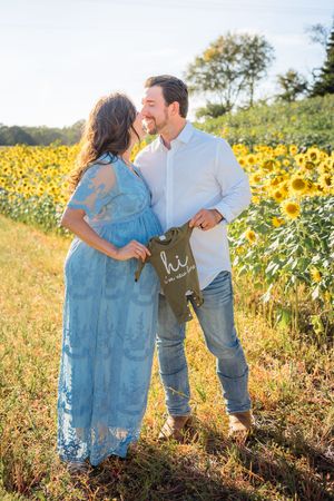 Couple sharing a romantic moment in a beautiful sunflower field during sunset.