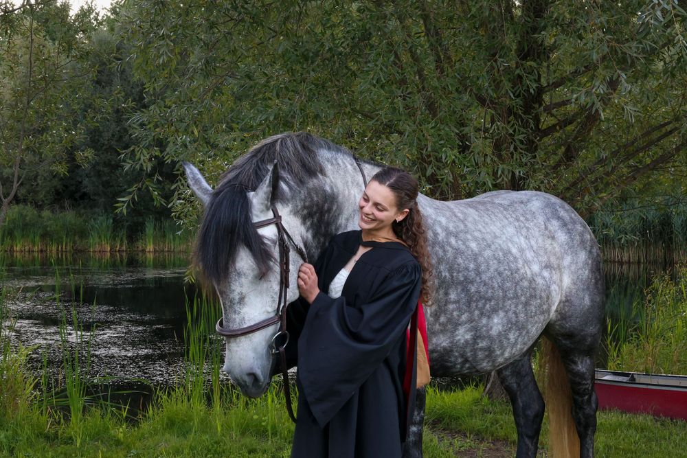 Girl with horse in front of lake