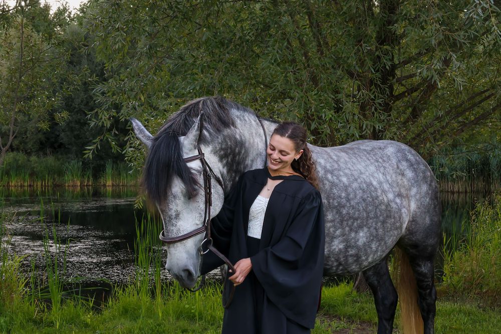 Girl with horse in front of lake