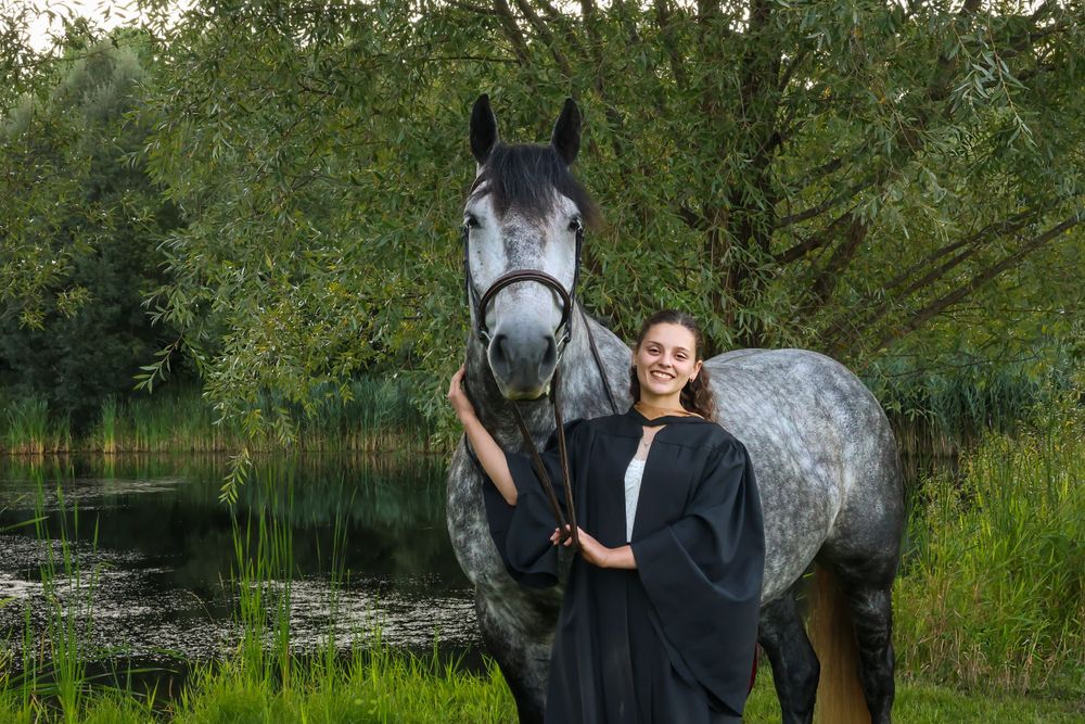 Girl with horse in front of lake