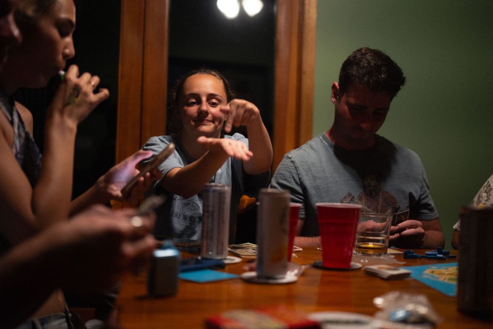 Multiple people gathered around a table enjoying a social gaming session.