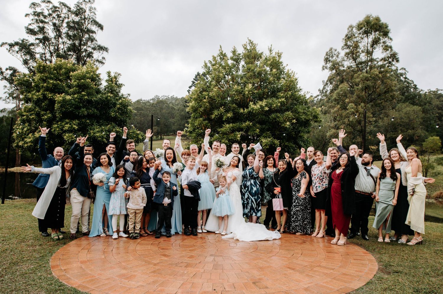 Large group wedding photo of guests and wedding party on an outdoor dance floor.