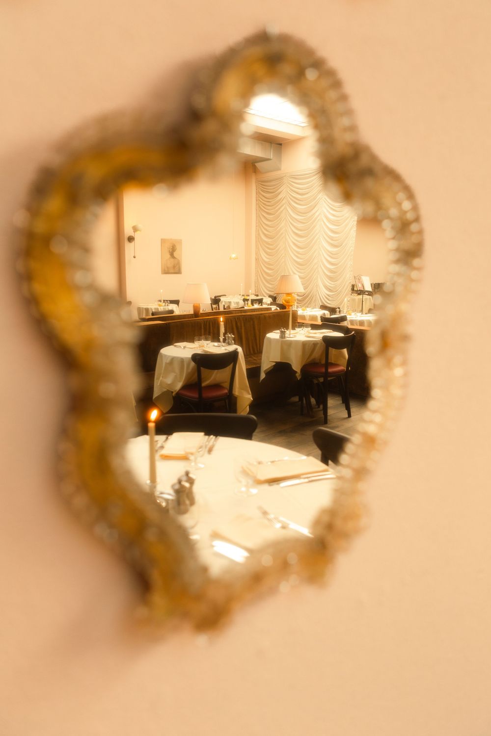 Ornate golden mirror frames reflecting elegant restaurant interior.